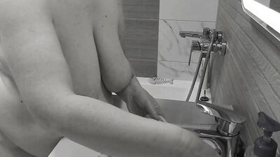 A mature bbw milf with big natural tits washes her sex toys.