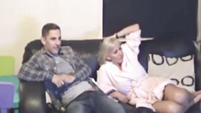 Blonde girl and her boyfriend are cuddling on the couch