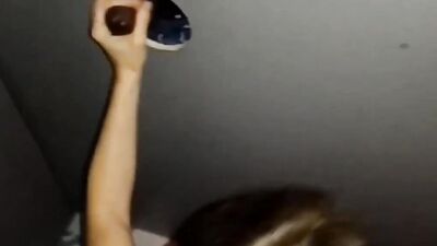 White girl strokes and sucks a big black cock through gloryhole