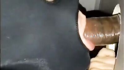 White girl strokes and sucks a big black cock through gloryhole