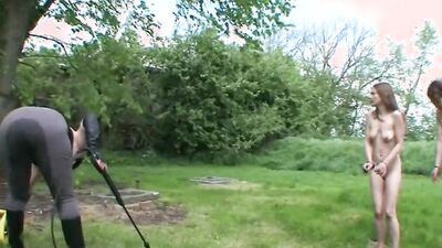 Two submissive girls are bound naked and flogged in the yard